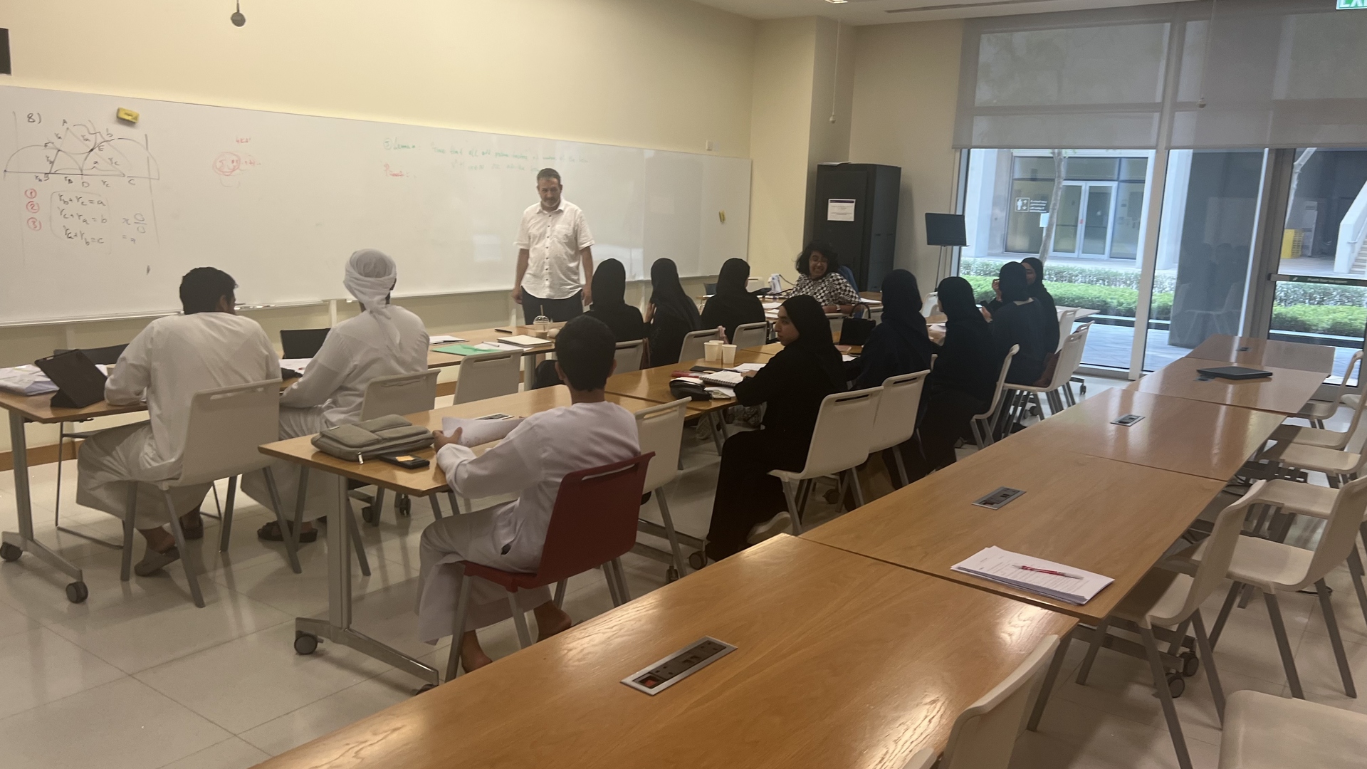 Olympiad instruction in progress, geometry diagrams on the whiteboard